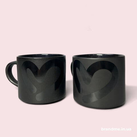 Дві чорні чашки з глянцевим принтом у формі серця на матовому фоні