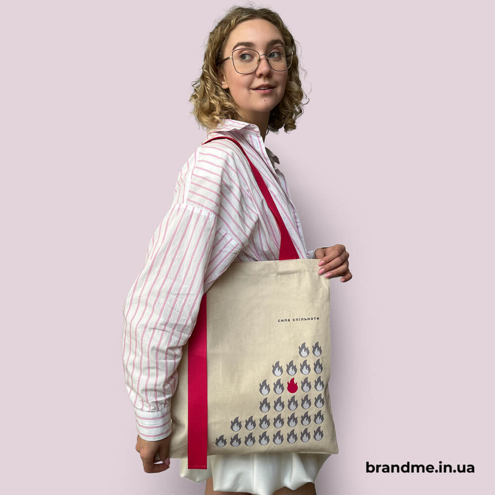 Бежевий шопер із яскравими рожевими ручками та принтом “Сила спільноти”