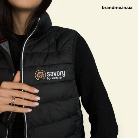 Вишитий логотип Savory на чорній стьобаній жилетці — брендування одягу