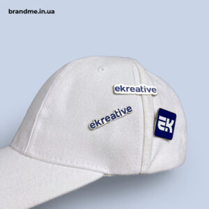 Литі піни для Ekreative на брендованій кепці Литі піни з логотипом Ekreative, закріплені на білій брендованій кепці